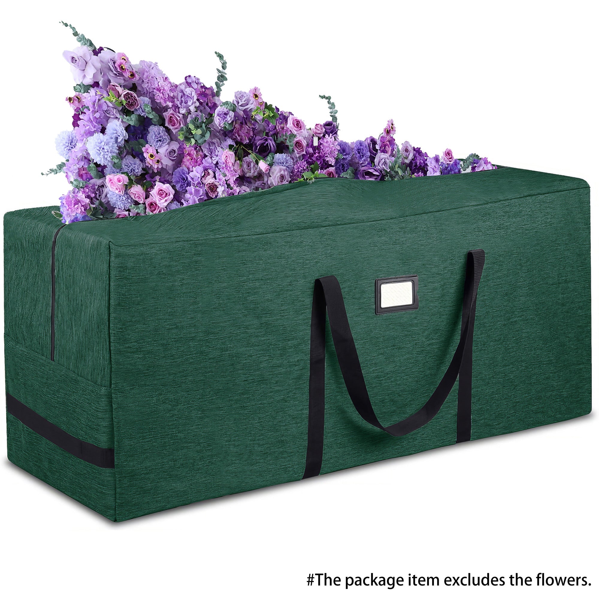 This image shows a large, dark green storage bag with black handles and a rectangular label patch on its side. The bag appears to be made of a durable fabric, likely for carrying or storing items. At the top of the bag, there is a display of colorful artificial flowers in various shades of purple and pink. Notably, a caption at the bottom indicates that “The package item excludes the flowers,” clarifying that the flowers are not part of what is being sold.