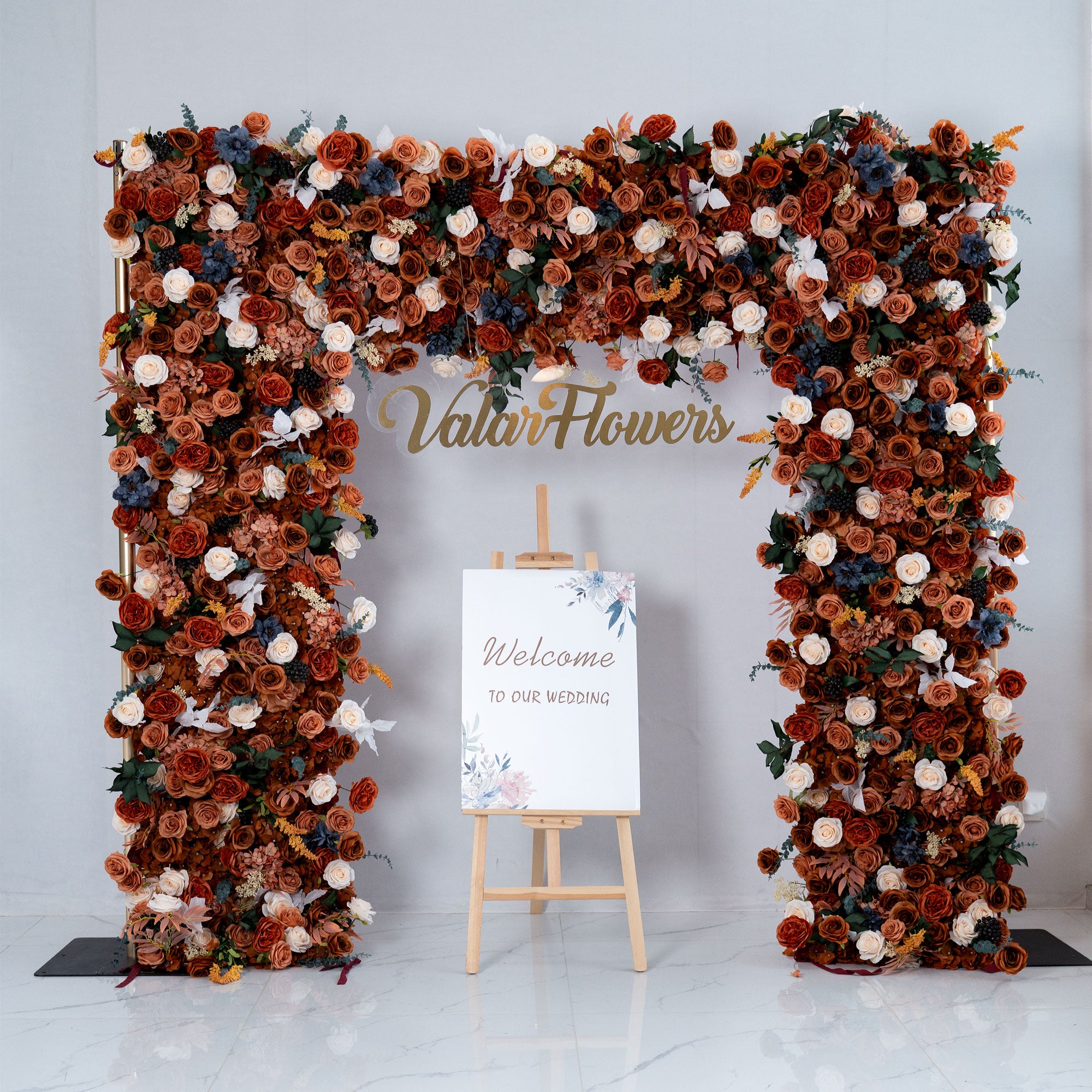 Floral arch with 'Valer Flowers' branding and a 'Welcome to our wedding' sign on a white background.