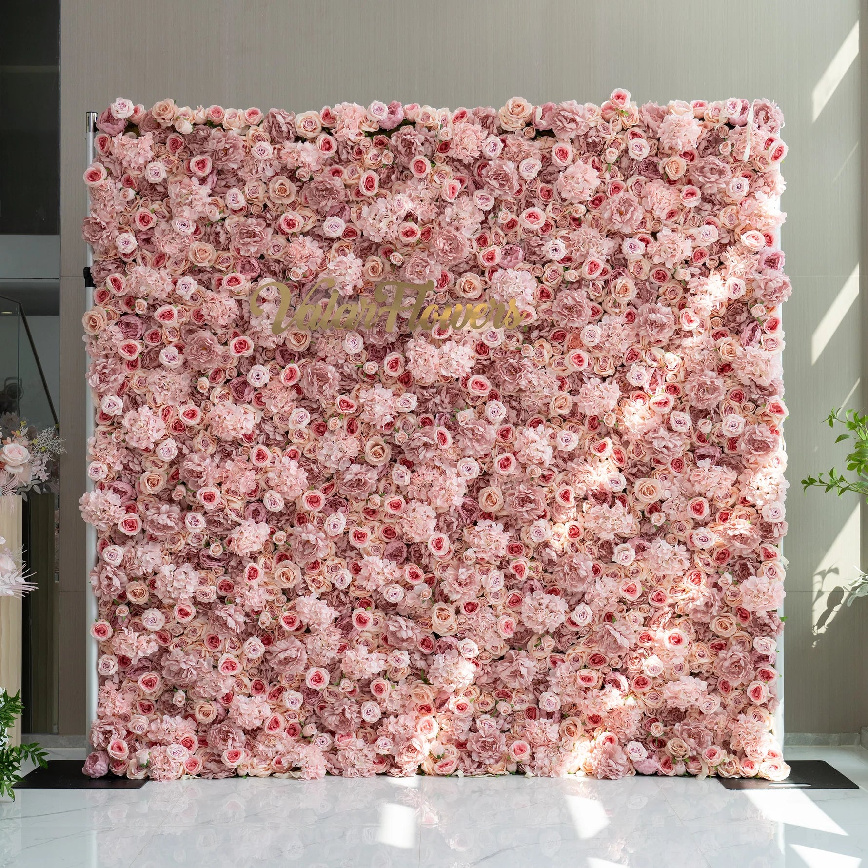 Floral wall with pink and white flowers and a visible brand name.
