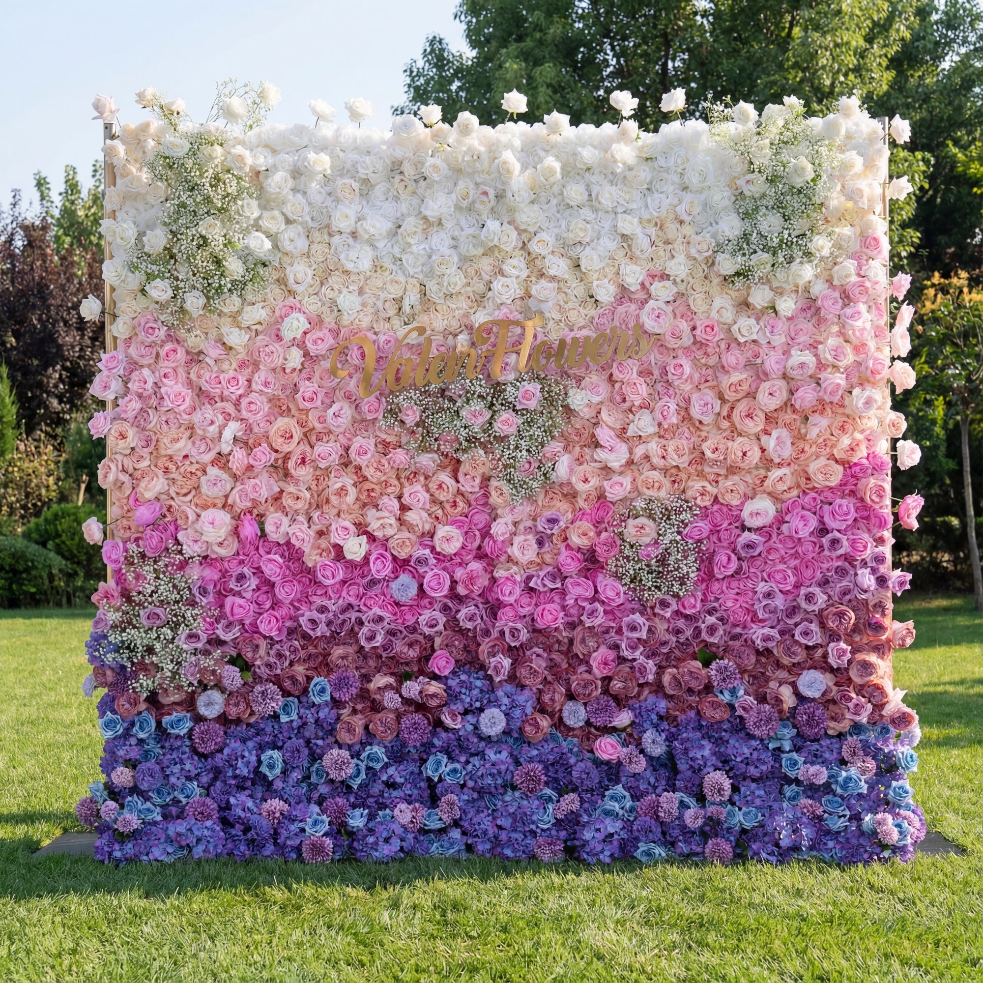 Floral wall with a gradient of colors and 'Natalie' written on it, outdoors.