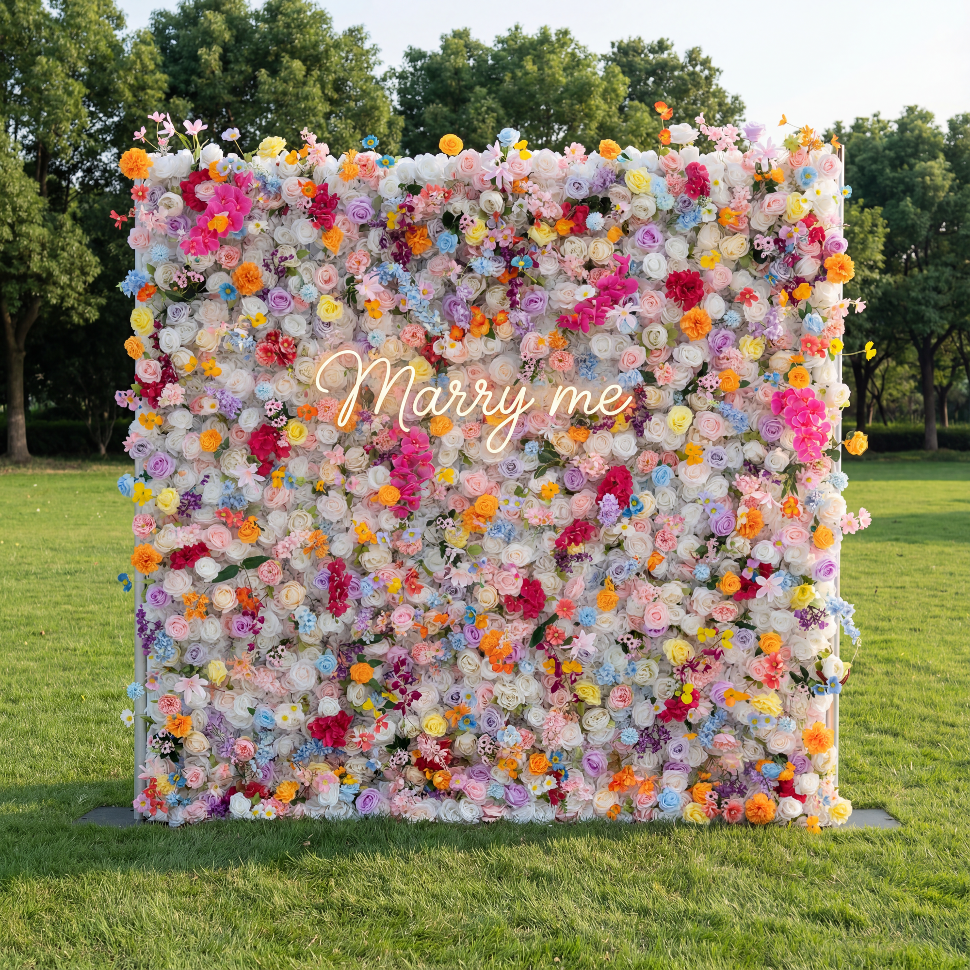 Floral wall with 'Marry me' text in a park setting