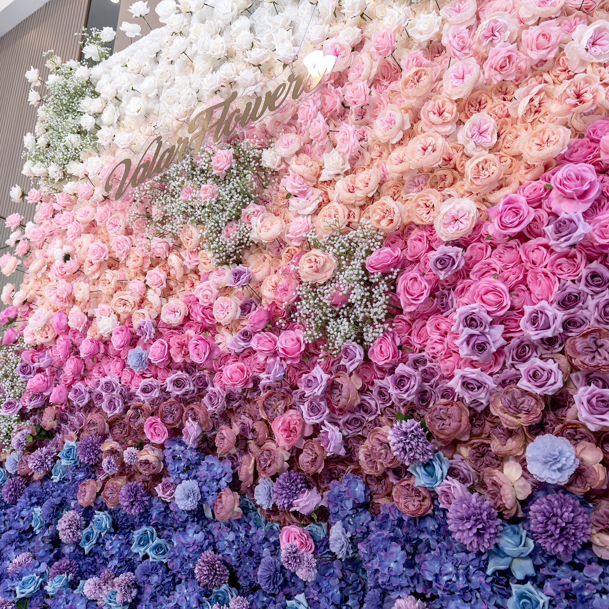 Gradient flower wall with pink, purple, and blue flowers.