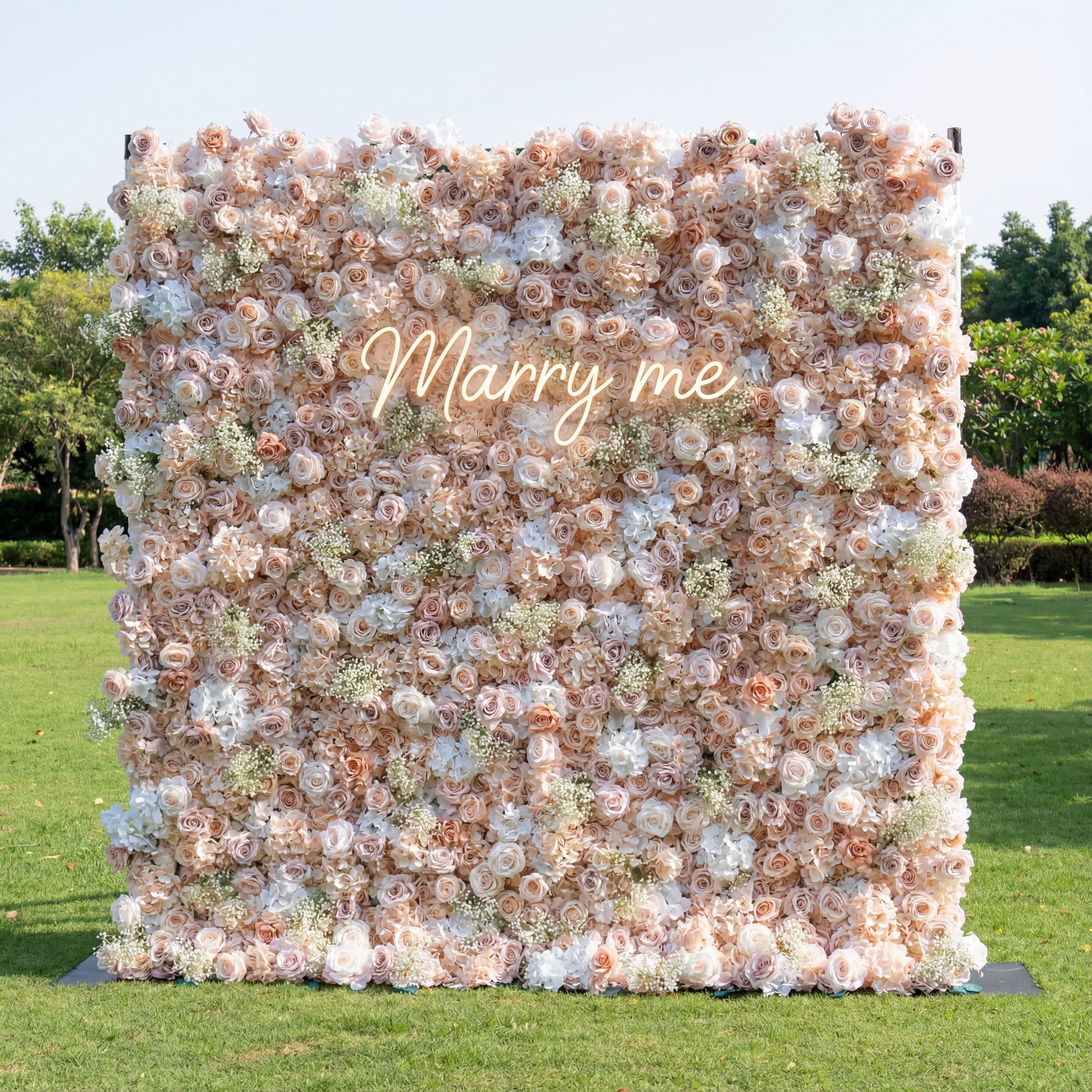 Floral wall with 'Marry me' text in an outdoor setting