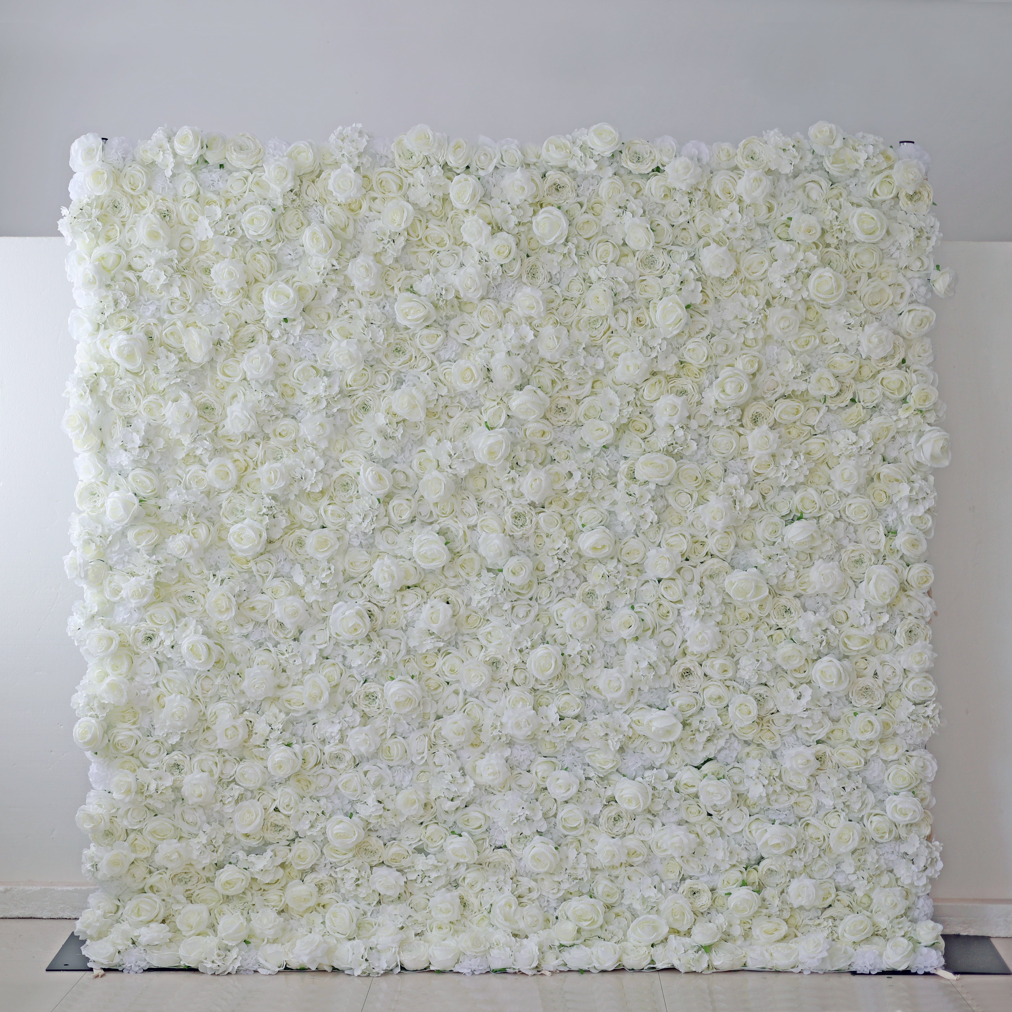 A large artificial white flower wall backdrop designed for events and weddings.
