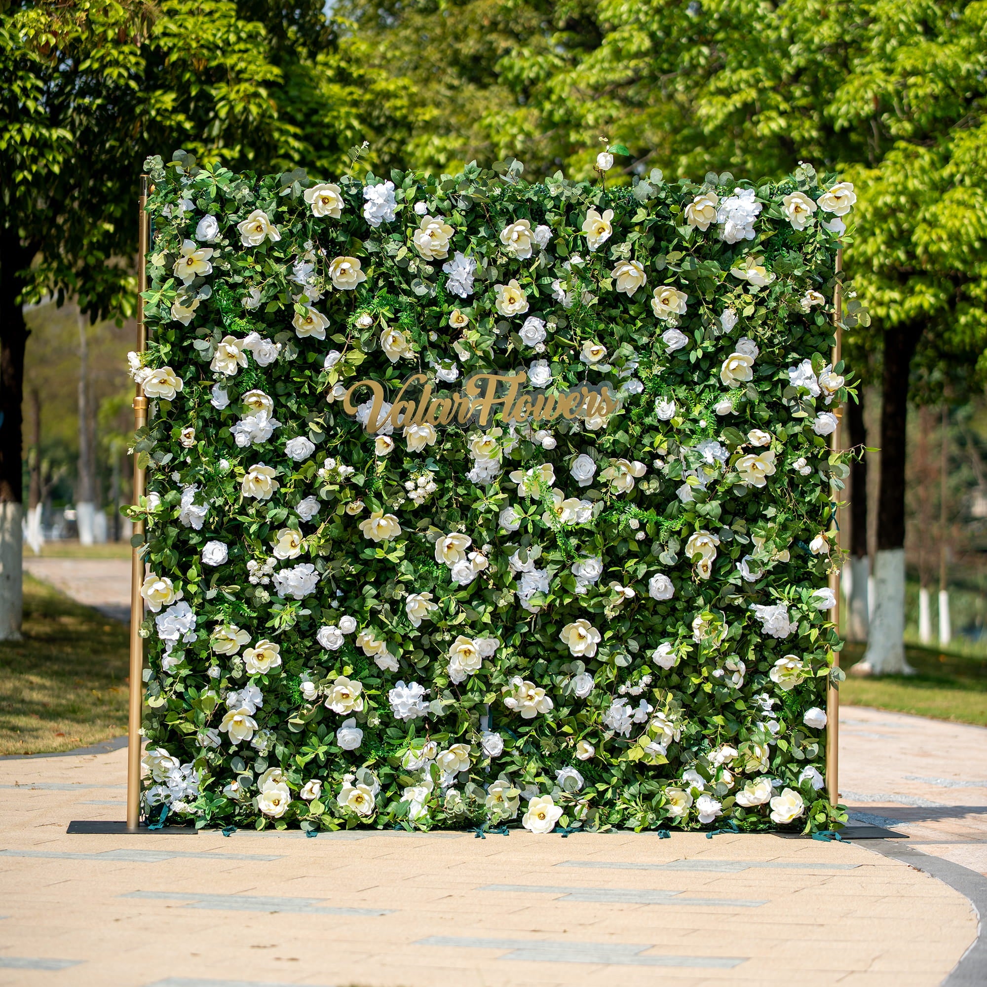 This backdrop features a lush arrangement of artificial green foliage interspersed with white flowers, including roses and camellia - like blooms. The color scheme is a fresh combination of vibrant green and pure white.
The golden - hued "Valar Flowers" sign adds an elegant touch. The overall style is natural and sophisticated, making it suitable for various events such as weddings, corporate functions, or garden parties.