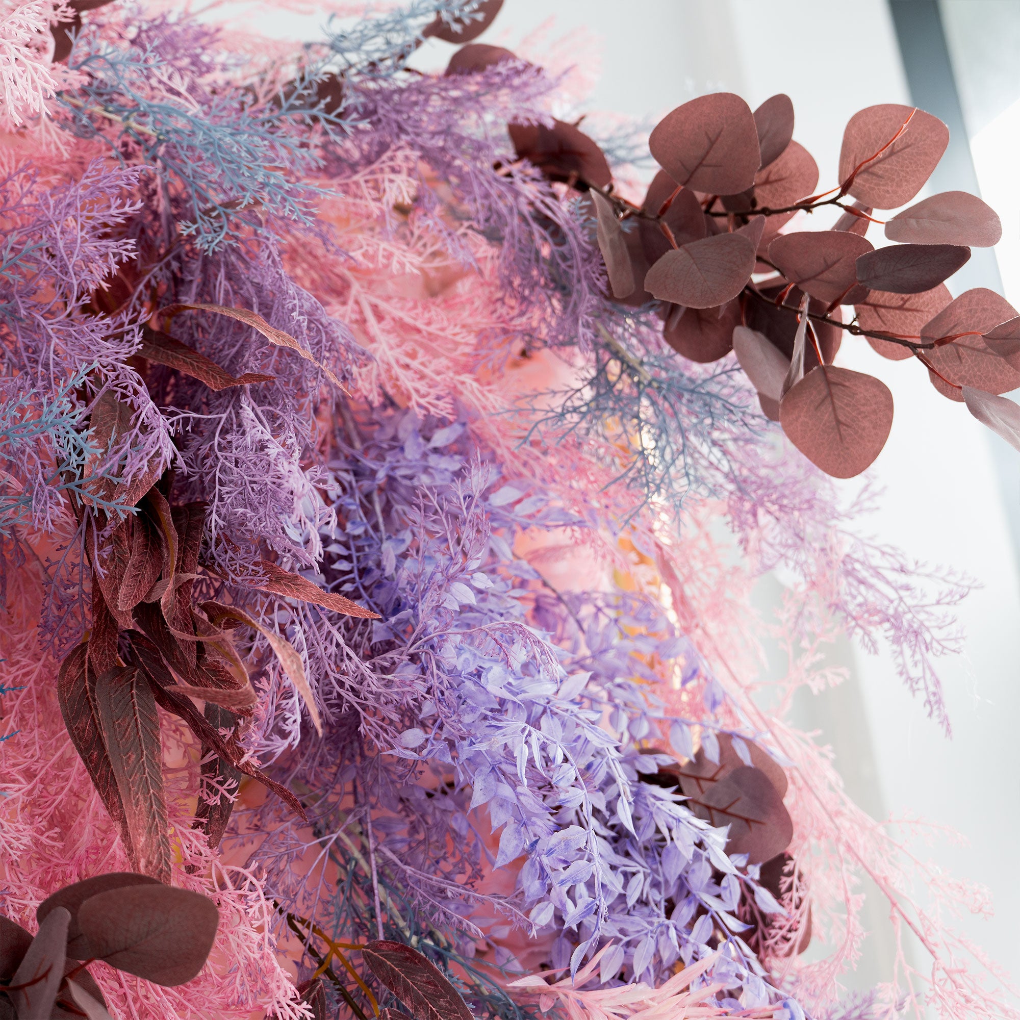 Dreamy pink and purple wedding flower wall with dimensional artificial leaves and ferns