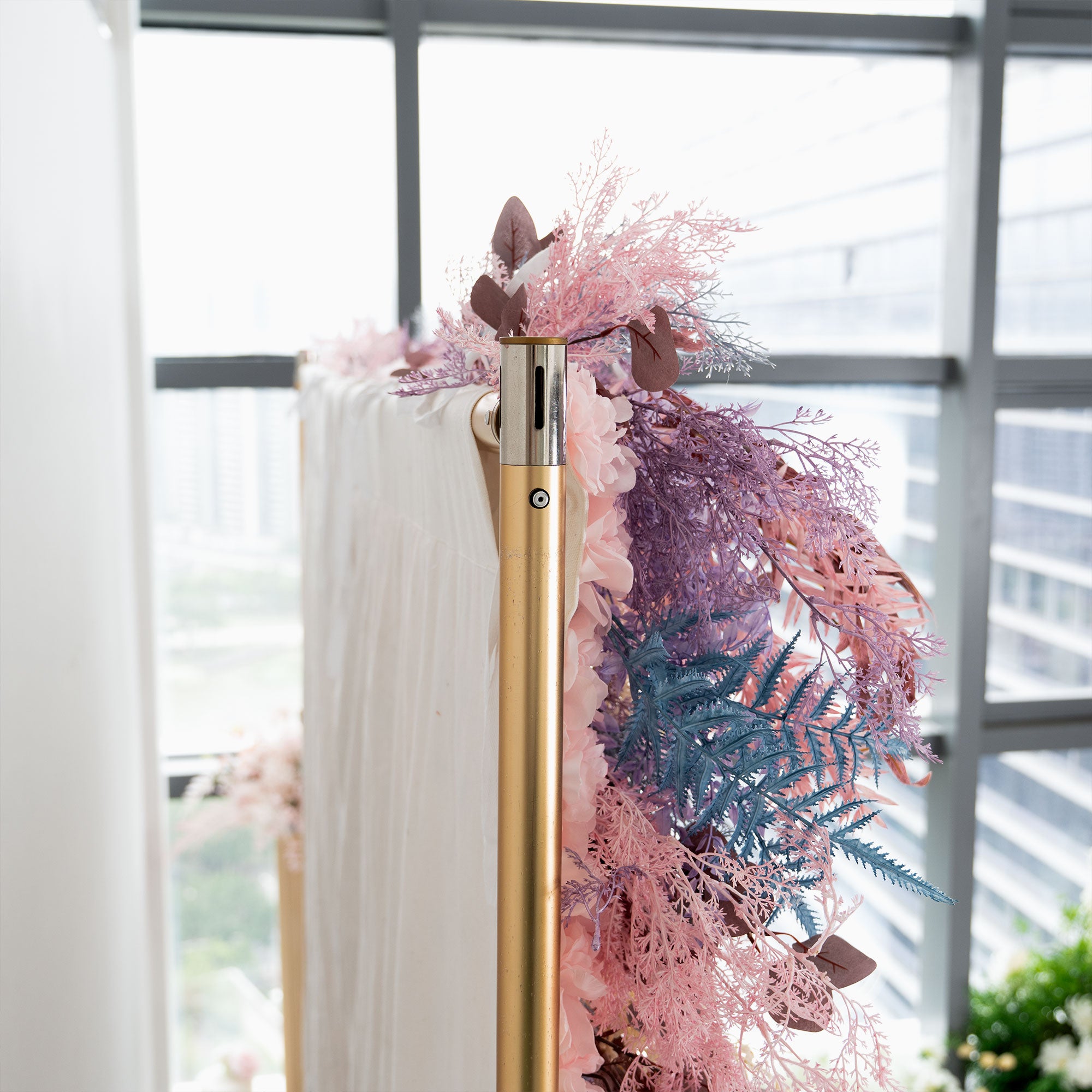 Pastel-themed floral wall with realistic lavender and pink artificial leaves and ferns