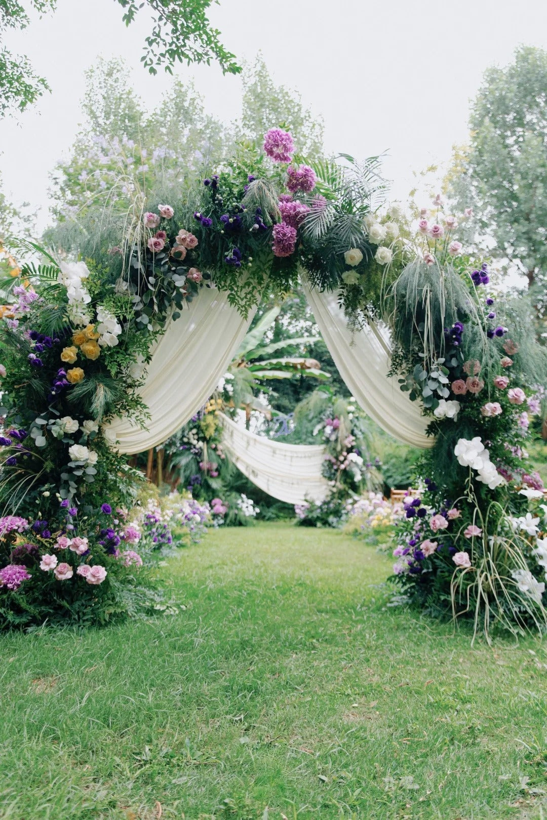 Romantic Purple and White Garden Wedding with Lush Floral Arch and Elegant Drapery