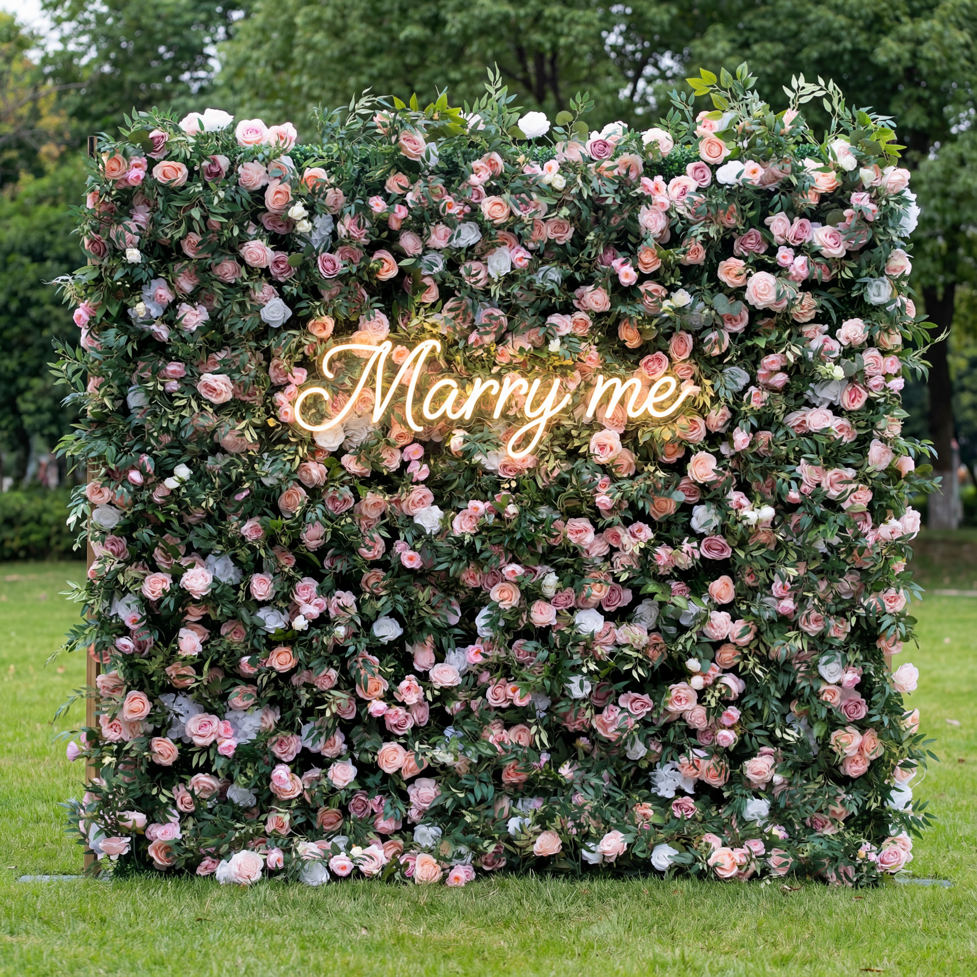 Floral wall with 'Marry me' neon sign in a garden setting