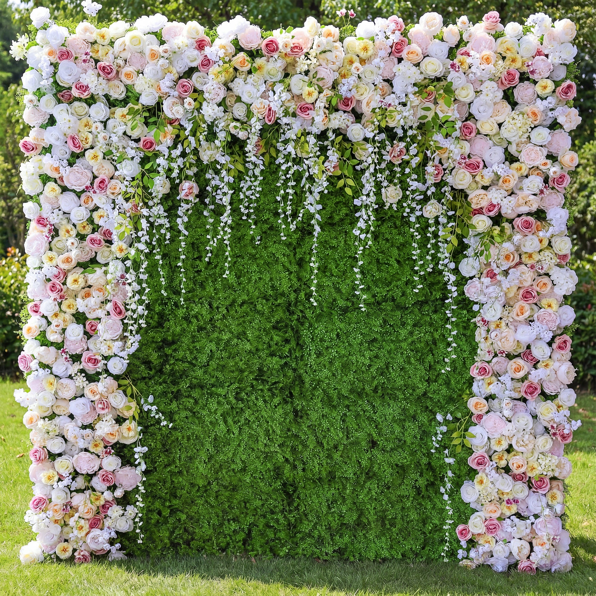Floral arch with pink, white, and yellow flowers against a green hedge backdrop