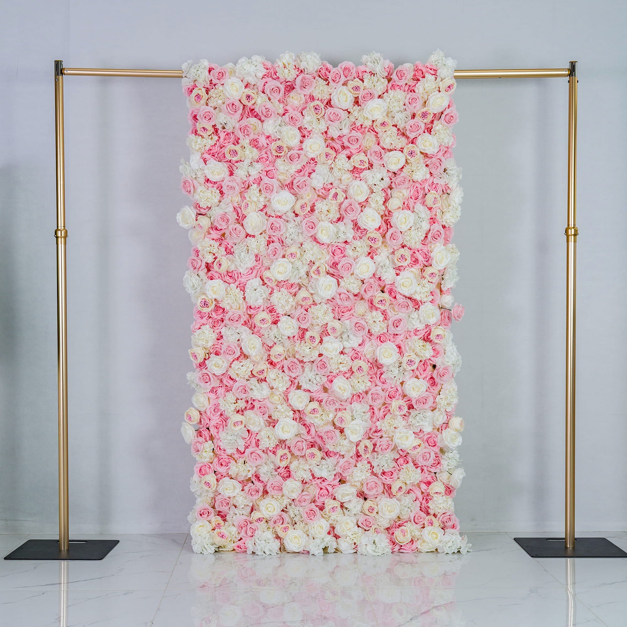 This photo features a large floral backdrop densely covered with pink and white roses, creating a soft and romantic color scheme. Mounted on a golden frame, it exudes elegance. Ideal for weddings, bridal showers, or other romantic events, its pastel hues and lush arrangement give a dreamy, sophisticated style. Size appears substantial, making a bold decorative statement. 