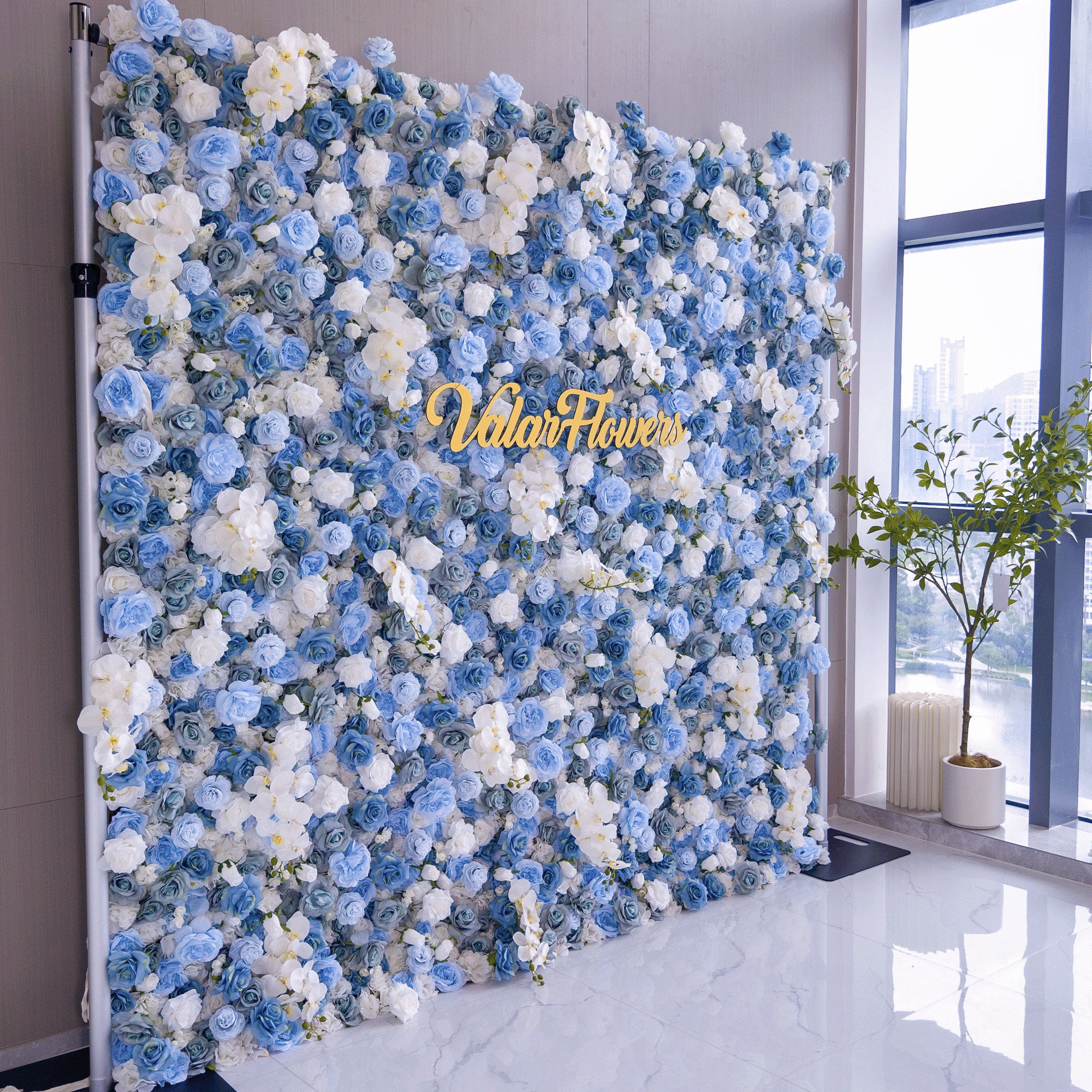Elegant artificial flower wall featuring a blend of blue and white roses, set outdoors with greenery in the background, ideal for serene event decor. VF-348-6
