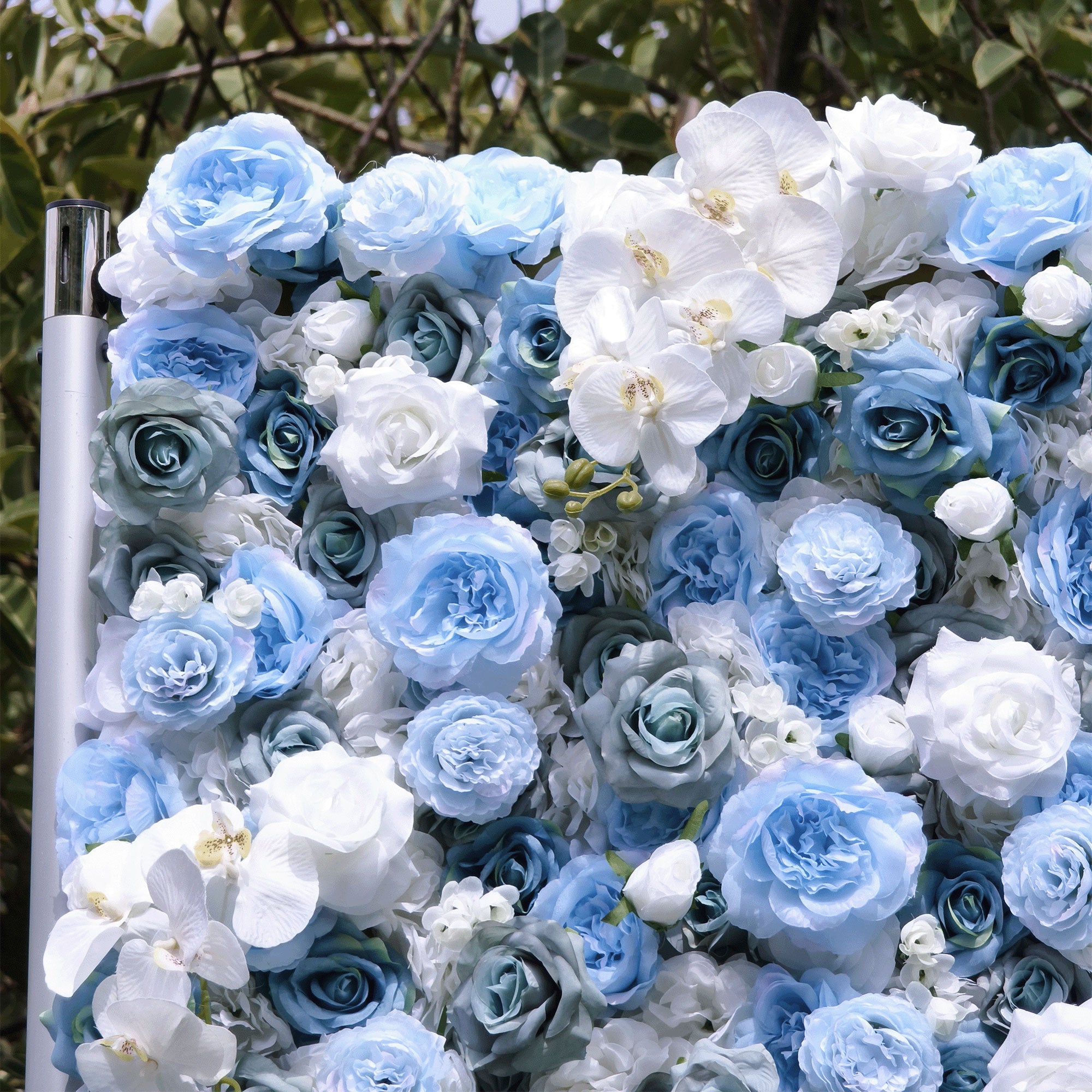 Elegant artificial flower wall featuring a blend of blue and white roses, set outdoors with greenery in the background, ideal for serene event decor. VF-348-8