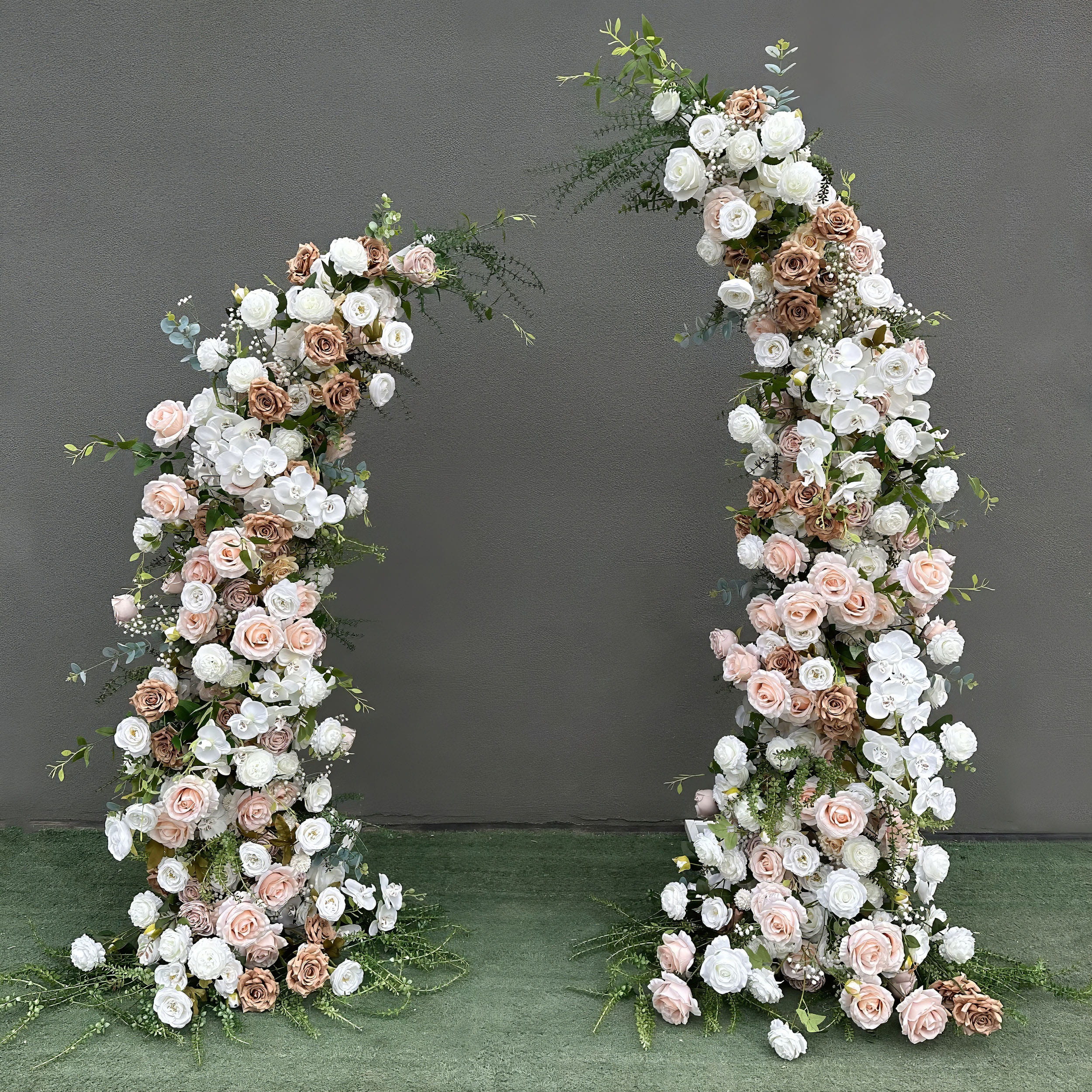 Beautifully designed artificial floral arch for weddings, ceremonies, and special events. Features blush pink, white, and earthy brown roses, plus white orchids with lush greenery. Arranged in a cascading effect on a sturdy frame. Ideal for indoor/outdoor use. Romantic, elegant, and timeless.