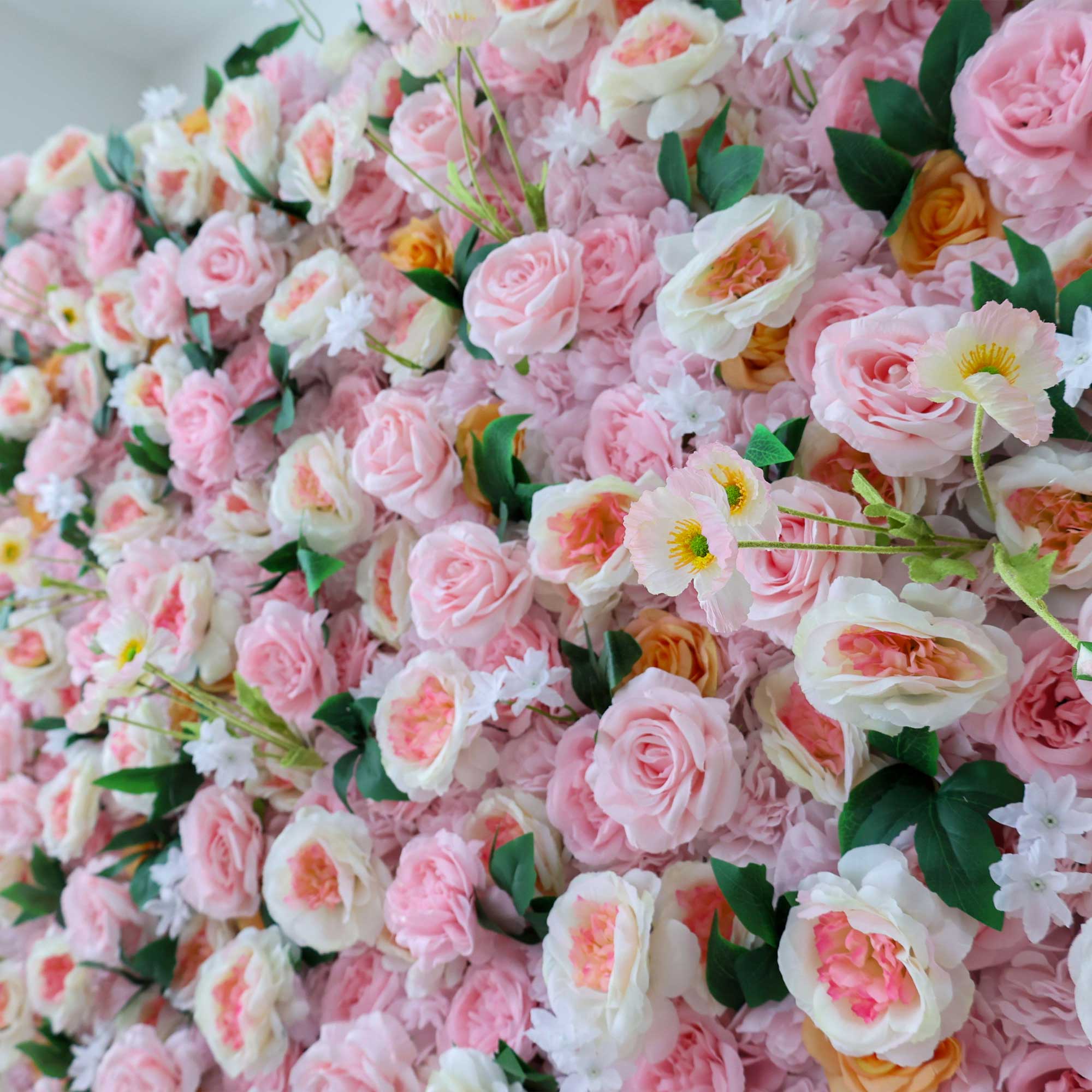 Handcrafted 5D artificial flower wall backdrop with soft pink and peach roses, accented with green leaves, set against a light background. Ideal for weddings, celebratory events, and photoshoots, adding a cheerful and inviting ambiance. VF-413-3