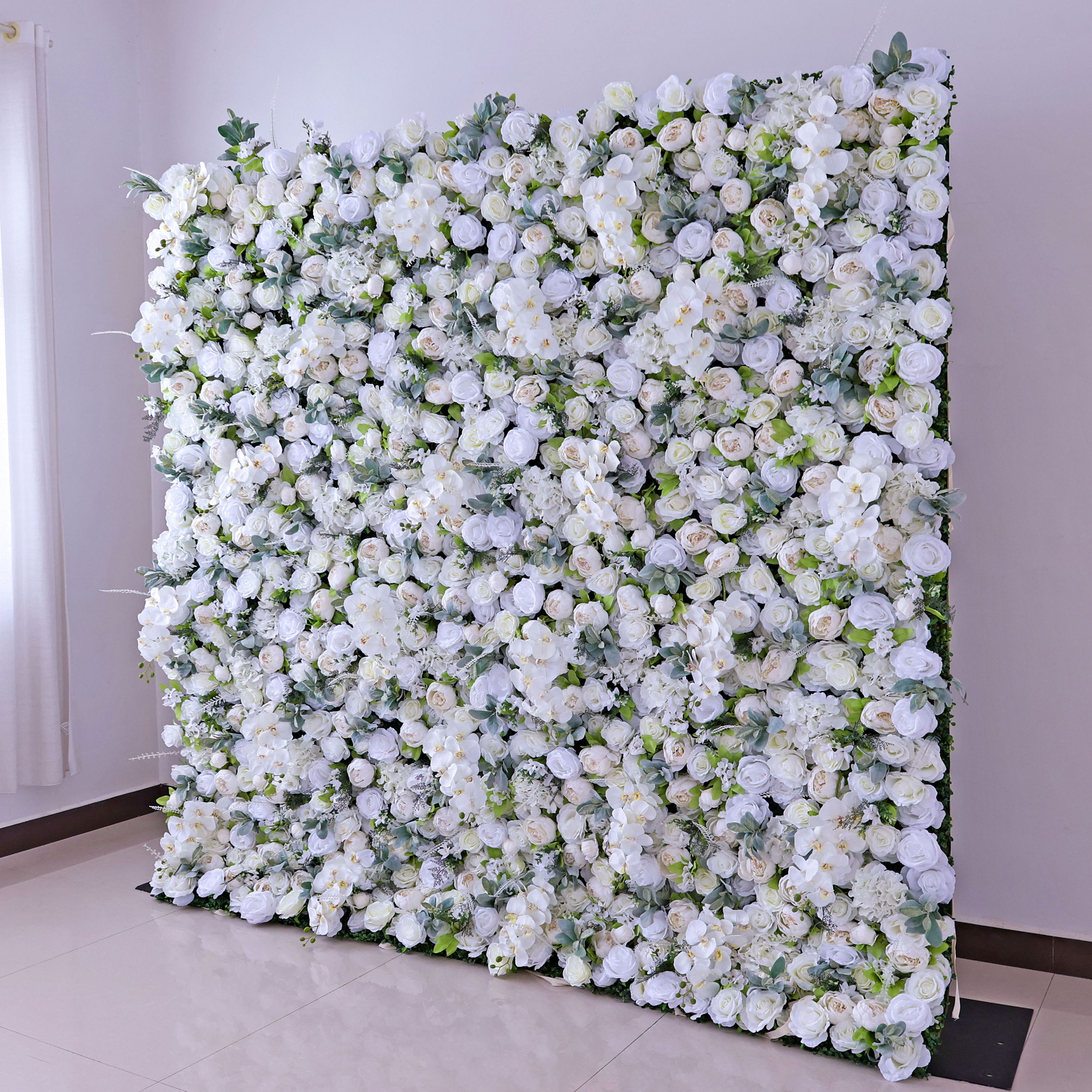 The ValarFlowers artificial flower wall is a stunning decor piece. It features a dense arrangement of white flowers with green leaves, creating a pure and elegant look. Ideal for weddings and events.