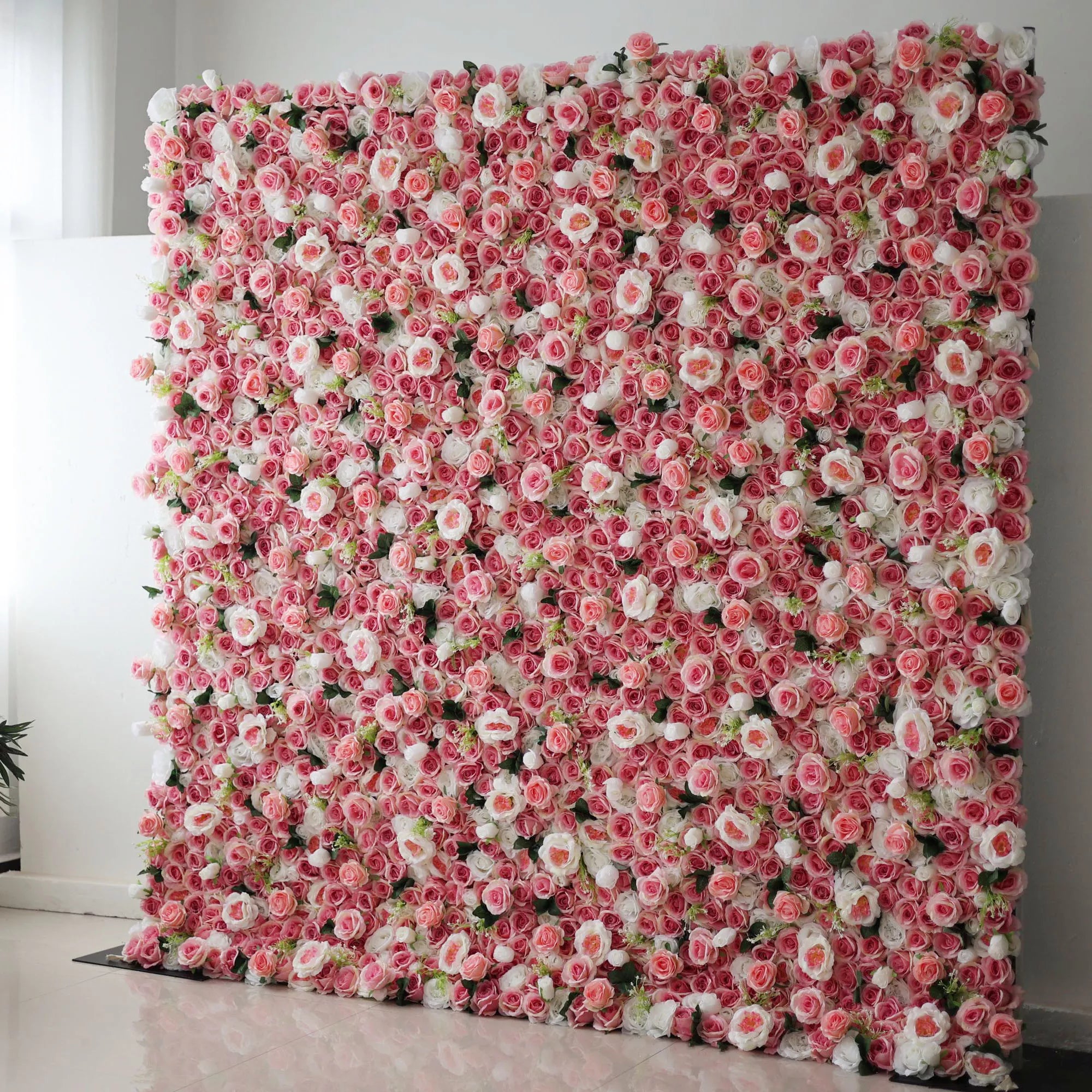 Valar Flowers' Artificial Fabric Flower Wall is a radiant sea of rosy elegance. From blush to fuchsia, punctuated by white roses, it's the epitome of timeless charm, turning any event into an unforgettable fairy tale.